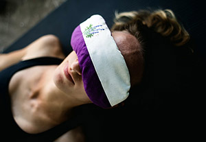 yoga savasana resting pose using an eye pillow