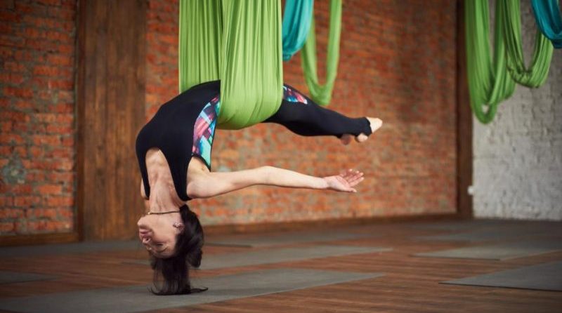 Aerial aka Suspended Yoga releases tension on muscles and bones. Increases spine flexibility, strengthens the core.. From YogaGrit.com and USNews/Health 2018